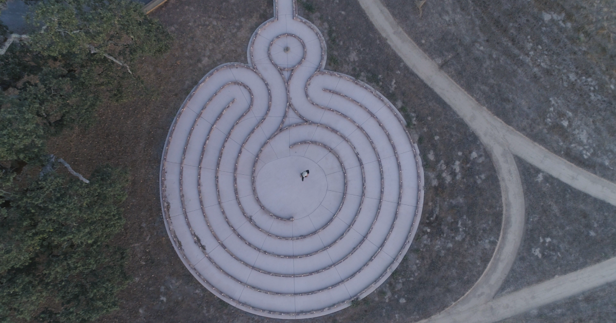 at dusk a drone overhead photo of the Labyrinth with one person in the center