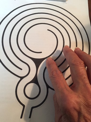 the raised line printed labyrinth with a hand hovering over the lower right side of the labyrinth